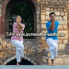 Two practitioners demonstrate Garudasana (Eagle Pose) against a historic backdrop. This image represents the balance and focus cultivated in our 'Mindful Sadhana & Self-Development' online course, designed for intermediate students and teachers.