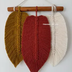This simple feather wall hanging with three leaves in rust, mustard, and cream is perfect for a minimal, bohemian look.