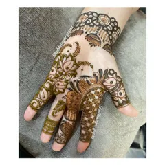 This designer mehndi plays with negative space, leaving parts of the skin clear to make the patterns pop. The combination of floral elements and detailed finger work makes it very eye catching.