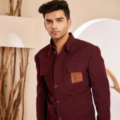 A frontal view of the maroon shacket, highlighting its clean design and the contrasting leather pocket detail that sets it apart.