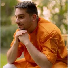 A candid portrait of the groom during his Haldi ceremony. His relaxed smile and the warm, natural light create a happy and serene image.