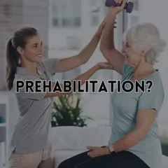 This image shows a physiotherapist guiding a senior client through a strengthening exercise, representing the core of prehabilitation. This process is about building physical and mental stamina before surgery.