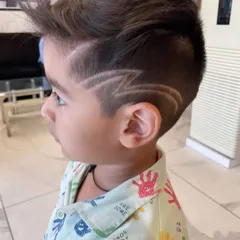 Even the little ones get a rockstar look here. I specialize in fun, creative hair art for kids, like this sharp lightning bolt design, making their haircut experience exciting and stylish.