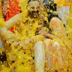 A candid moment of pure bliss during a 'phoolon ki haldi', where the couple is completely covered in a shower of bright yellow marigold petals. These are the joyful memories I strive to create.