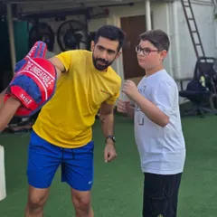 Focus and determination in action. A coach holds up the pads, preparing a young athlete to practice his punching technique, ensuring every movement is precise and powerful.