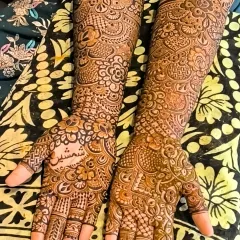 A beautiful example of full-hand mehendi with a mix of floral, paisley, and geometric check patterns. The density of the design ensures a stunningly dark stain.