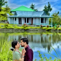 A romantic pre-wedding portrait in front of a traditional Himachali house reflected in a tranquil lake. This image combines natural beauty with local architecture for a unique feel.