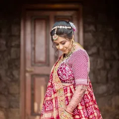 This bride's look is a beautiful example of soft glam. The makeup features blush tones on the eyes and cheeks, paired with a traditional bandhani-style dupatta, creating a look that is both modern and rooted in tradition.