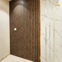 A detailed shot of the textured wall treatment, showing the contrast between the vertical wood fluting and the smooth marble panel with thin gold strips.
