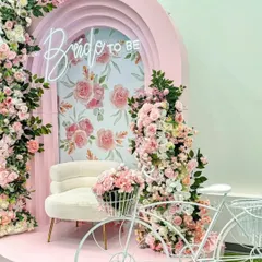 A wider view of the pink floral "Bride to Be" setup, featuring a decorative white bicycle. This charming detail adds a touch of whimsy and serves as a wonderful prop for photos.