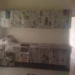 A kitchen area fully prepped for painting, with cabinets and countertops carefully covered to prevent any damage or mess.