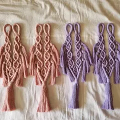 A set of our macrame curtain ties laid out, showing the intricate knot work and design. We offer them in pairs to beautifully frame your windows.