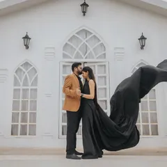 A glamorous shot with a flowing black dress against a white chapel-style set. This high-contrast, elegant look is a popular choice for a sophisticated pre-wedding album.