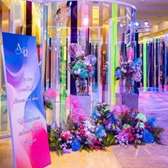 A welcome sign and floral installation at the start of the iridescent tunnel. The colorful, reflective design immediately immersed guests in the event's unique and contemporary theme.