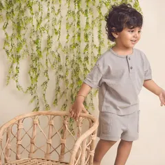 A candid shot of a toddler exploring the studio. The natural textures of the chair and greenery add a lovely touch to this kids' portrait.