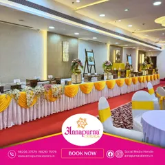 A well-decorated buffet line enhances the dining experience. Here, we used bright yellow drapes and floral arrangements to create a festive and inviting food station for a celebration.