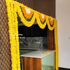 This marigold flower decoration is perfect for archways or kitchen entrances during a housewarming. The bright yellow garlands add a pop of color and traditional charm to the celebration.