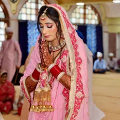 A candid moment of prayer during the Anand Karaj ceremony. The makeup is designed to look beautiful from every angle, with soft, blended eyeshadow and a matte finish that lasts through all the rituals.