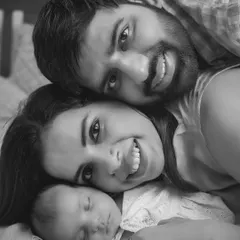 A perfect family cuddle. This black and white newborn portrait captures the pure joy and peace of a family of three, lost in their own little world.