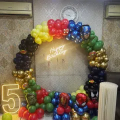 Superhero parties are one of our most requested kids' themes. For this 5th birthday, we assembled the Avengers with a full ring balloon arch in character colors, a 'Happy Birthday' neon sign, and a light-up number '5'. We can bring any hero universe to life for your little one.
