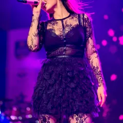 A magical stage moment. Dhvani Bhanushali performs in a custom black lace and tulle outfit from Seraphine Design Studio, set against a dreamy moonlit backdrop.