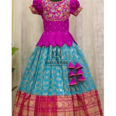 A stunning Banarasi Pattu lehenga in magenta and turquoise. The blouse features intricate bird-motif embroidery, and the skirt has a beautiful gold zari border.