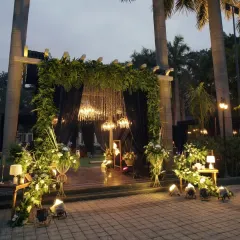 A grand entrance decor with lush greenery, elegant drapery, and crystal chandeliers, setting a lavish tone for the event.
