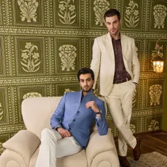 Showcasing two distinct but complementary looks for the groom's friends. A blue linen bandhgala and a beige linen suit, both tailored to perfection for a sophisticated daytime event.