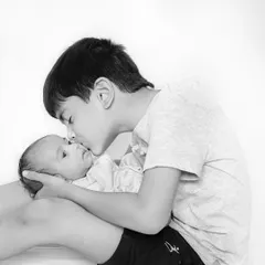 A protective kiss from a big brother. These black and white sibling portraits are timeless and focus purely on the emotional bond between your children.