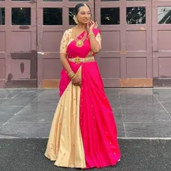 A full-length view of the custom lehenga saree. The combination of the neutral beige skirt and the bright pink dupatta creates a balanced and festive look, perfect for a special celebration.