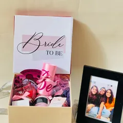 This 'Bride to be' gift set includes a personalized photo frame alongside a box of pampering goodies. It’s a heartfelt gift from friends to celebrate the bride's journey.