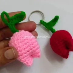 A pair of our crochet tulip keychains, shown here in soft pink and vibrant red. Each tulip has green leaves and is attached to a sturdy keyring, making a sweet and simple gift.