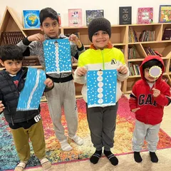 A group of friends proudly displaying their snowman crafts from the winter camp. It’s wonderful to see them create together and celebrate each other's work.