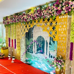 A unique Pichwai art-inspired backdrop featuring a beautiful peacock and lotus garden scene. This artistic design, framed by a golden jaali and floral canopy, is perfect for clients looking for something truly special.