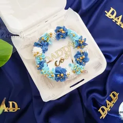 A special bento cake for Father's Day, decorated with a blue floral wreath and a "Daddy Cool" topper.