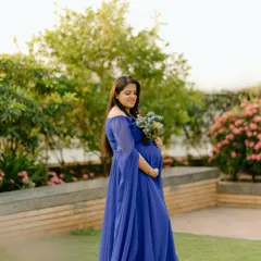 A vision in royal blue. This elegant gown with cape-like sleeves adds a touch of drama and grace to this outdoor solo maternity portrait.