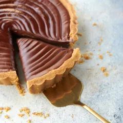 A perfect slice of my Signature Chocolate Tart. The rich, dark chocolate filling and crumbly, buttery crust create a simple yet elegant dessert that is a favorite for any occasion.