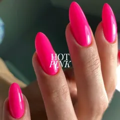 A close-up of this electrifying hot pink. The color is incredibly saturated and the application is flawless, creating a smooth, high-shine finish on these elegant almond-shaped nails.