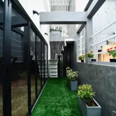 Where textures tell stories. This narrow passage is transformed into a green corridor with an artificial turf floor and potted plants, creating a pleasant transition space between different parts of the home.