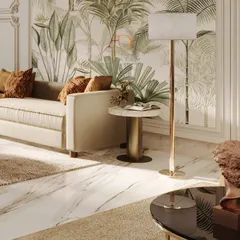 A close-up on the seating area, where a tropical botanical wallpaper is framed by classic mouldings, creating a beautiful fusion of styles. The plush sofa and warm cushions add a layer of comfort.