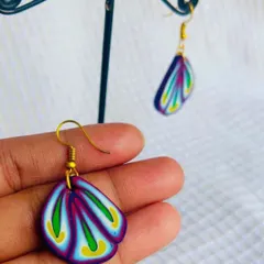 These fan-shaped polymer clay earrings feature a beautiful layered pattern. The clay is carefully blended to create these colors before being shaped and baked.
