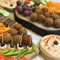 This party spread is all about fresh flavors and beautiful presentation. I've arranged falafel bites with toothpicks, feta and olive skewers, and bowls of creamy hummus, ready for guests to enjoy.