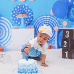 The moment of curiosity just before the smashing begins. This little one is carefully inspecting his first birthday cake, ready for the fun to start.