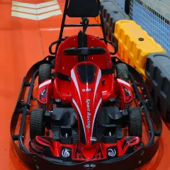 A close-up of one of our sleek, red electric go-karts. They are easy for kids to operate and have built-in safety features, including a sturdy frame and controlled speed.