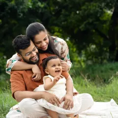 A family shares a heartfelt laugh during an outdoor session in a lush green park. Capturing these unposed, joyful moments is what makes outdoor family photoshoots in Mumbai so special.