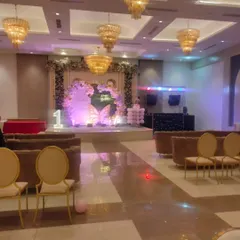 A wide shot showing the scale of a butterfly-themed birthday party in a banquet hall. The decorated stage serves as the main focal point for the event.