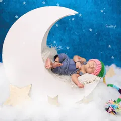 We can customize any theme with adorable accessories. Here, we added a colorful, handmade knit hat to the moon setup, adding a playful and personal touch to this dreamy newborn portrait.