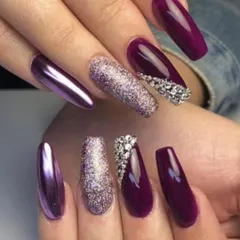 A glamorous set of long, coffin nails in a deep plum color. This design features a mix of textures, including purple chrome, full-coverage silver glitter, and intricate crystal patterns.
