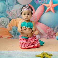 A sweet, direct-to-camera portrait of the baby in her mermaid outfit. The tiara adds a perfect touch of royalty to this fantasy photoshoot.