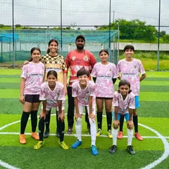 Our fresh and new girls' team posing with their coach. We are always excited to welcome new players and build the next generation of female footballers.